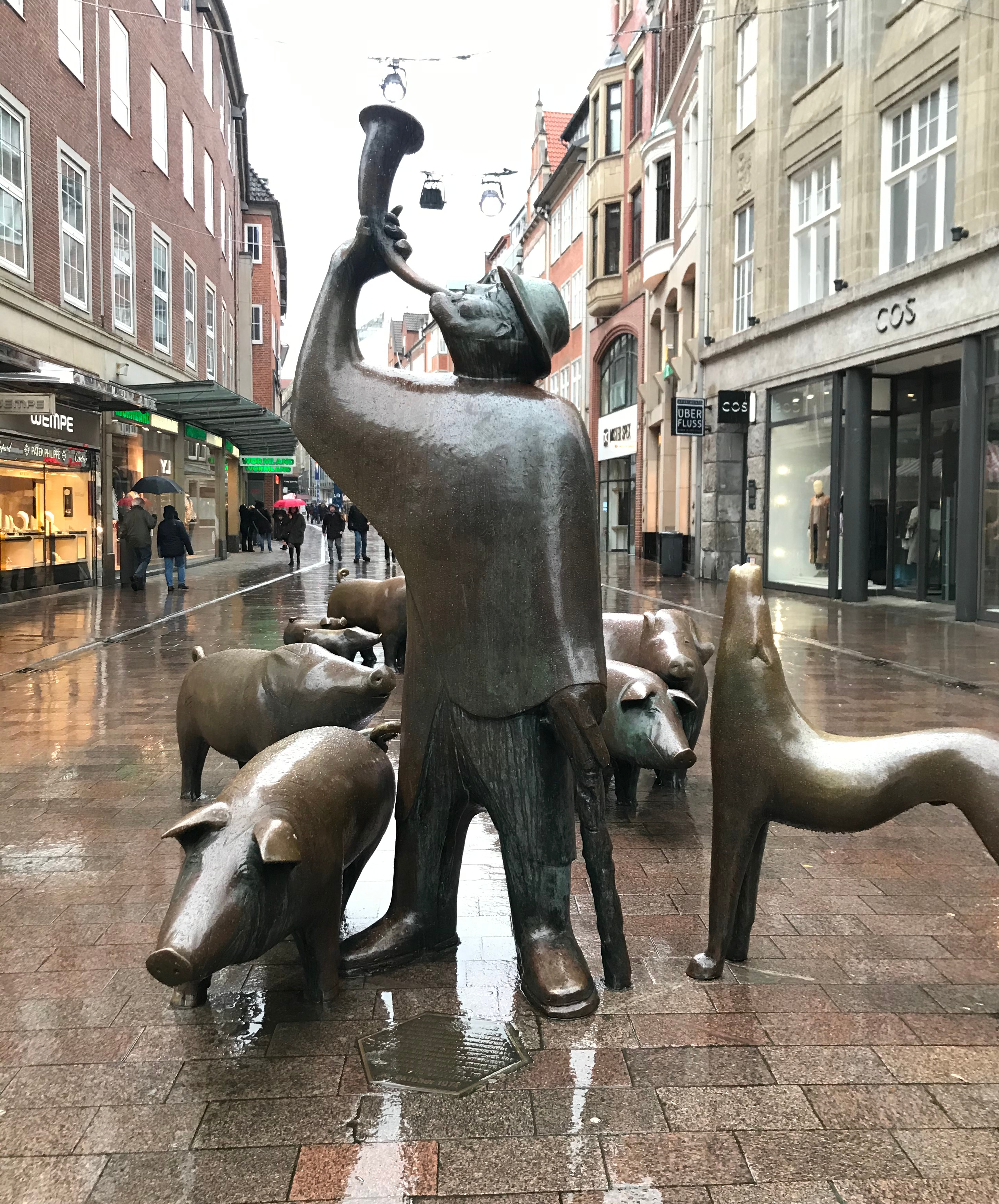 Bronze statue of a shepherd with pigs surrounding him